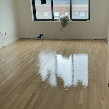 Water-damaged buckled hardwood floor repair in Boston condo - subfloor reinstalled and new hardwood laid with Nordic Seal finish by American Builder Hardwood Floor